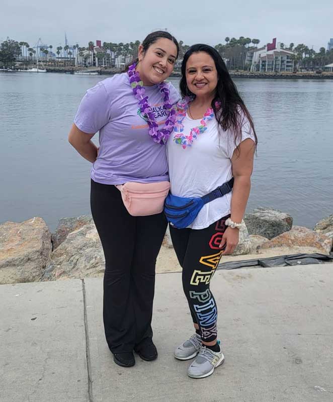 Fabiola posing with her mom in front of the marina
