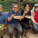 Group of party goers enjoying the outdoors while eating