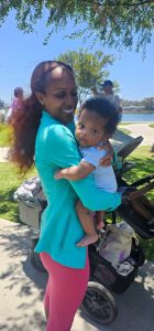 A mother smiles while holding her baby during Walk4Hearing